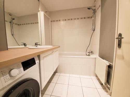 uma casa de banho com uma máquina de lavar roupa e um lavatório em Standing appartement avec vue sur la Mayenne em Laval
