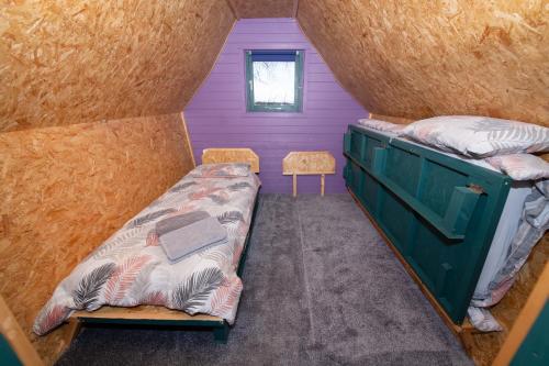 グレート・ドリフフィールドにあるSeaways glamping, Copper Beechのベッドと窓が備わる小さな客室です。