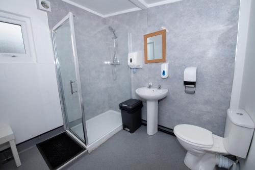 a bathroom with a shower and a toilet and a sink at Seaways glamping, Copper Beech in Great Driffield