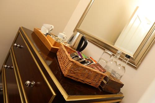 a bathroom vanity with a basket and a mirror at St Mary's Inn in Morpeth