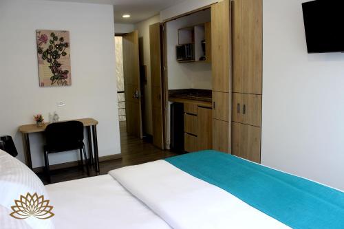 1 dormitorio con 1 cama y cocina con escritorio en Apartahotel Boutique Central, en Bogotá