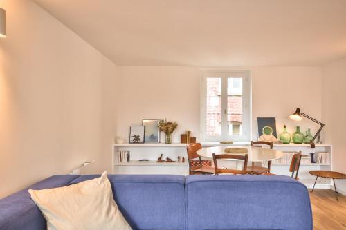 un salon avec un canapé bleu et une table dans l'établissement La maison du pêcheur, à Étretat