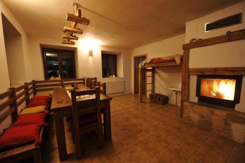 a living room with a fireplace and a table and a bed at Penzion Dvůr in Obora