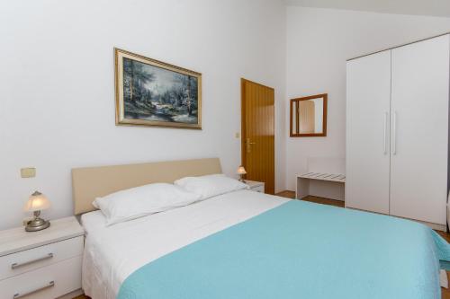 ein Schlafzimmer mit einem großen Bett mit einer blauen Decke in der Unterkunft MODERN APARTMENT WITH SEA VIEW in Dubrovnik