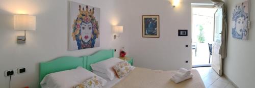 a room with a bed and a table with pillows at Stromboli Central Family Apartment - 3 Double Rooms in Stromboli