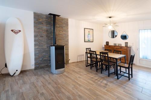 - une salle à manger avec une table et une planche de surf dans l'établissement La Cotinette, à La Cotinière