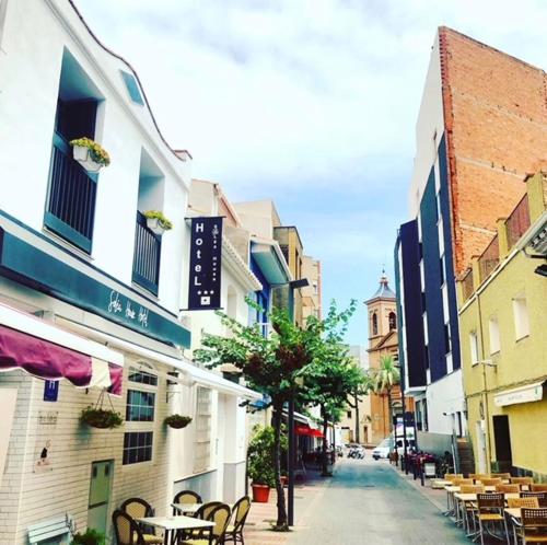 a city street with tables and chairs and buildings at Soléa House Hotel Boutique in Benicàssim
