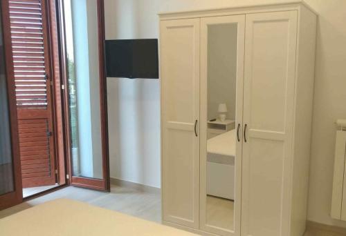 a white cabinet with a glass door in a room at Civico85 in Naples