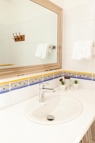 a bathroom with a white sink and a mirror at Angeli Gardens Boutique Hotel in San Pedro Sula