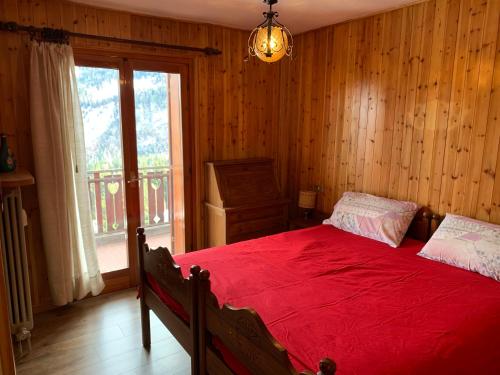 a bedroom with a red bed and a window at Appartamento panorama in Folgarida