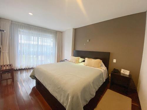 um quarto com uma cama grande e uma janela grande em Apartasuites BellHouse Bogotá em Bogotá