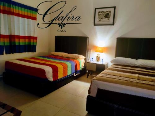 ein Schlafzimmer mit 2 Betten und ein Schild an der Wand in der Unterkunft Casa Glafira in Oaxaca de Juárez