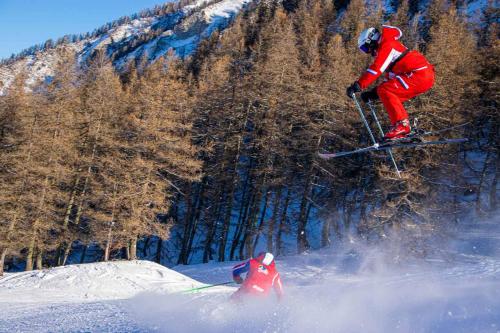 une personne sautant dans l'air à ski dans la neige dans l'établissement Les Garianes, à Saint-Léger-les-Mélèzes