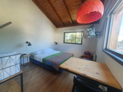 a bedroom with a bed and a table and a window at Trastienda Guest House in El Calafate