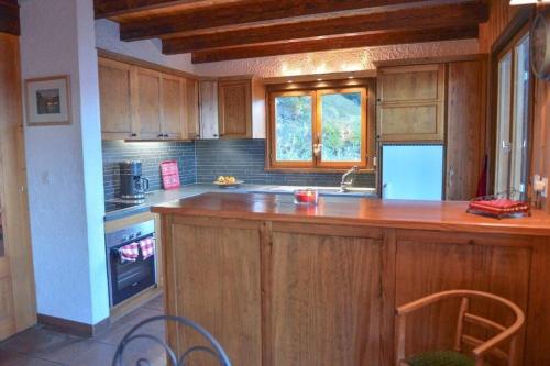 uma cozinha com armários de madeira e uma bancada em LA TZOUMAZ - VERBIER 4 Vallées - Grand Chalet 5 chambres, Ski IN/OUT, Sauna em La Tzoumaz