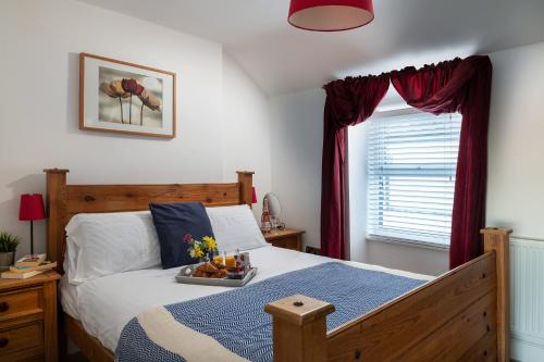 a bedroom with a bed with a tray of fruit on it at Conwy View Cottage in Conwy