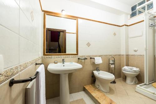 a bathroom with a sink and a toilet and a mirror at Bed And Breakfast Marina d'Aspra in Bagheria
