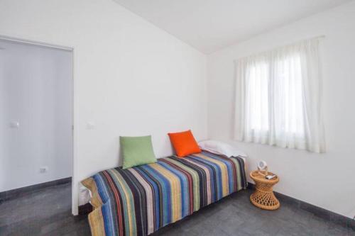 a bedroom with a bed with colorful pillows on it at Casa Azul: A magic place in an authentic space in Mosteiros