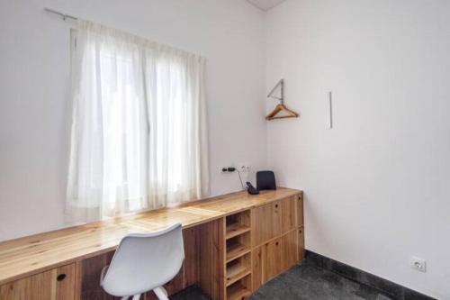 a desk with a chair in a room with a window at Casa Azul: A magic place in an authentic space in Mosteiros