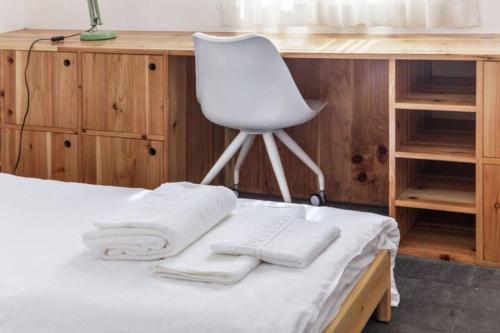 a desk with a chair and towels on a bed at Casa Azul: A magic place in an authentic space in Mosteiros