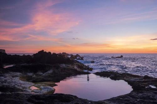 a sunset over the ocean with a body of water at Casa Azul: A magic place in an authentic space in Mosteiros