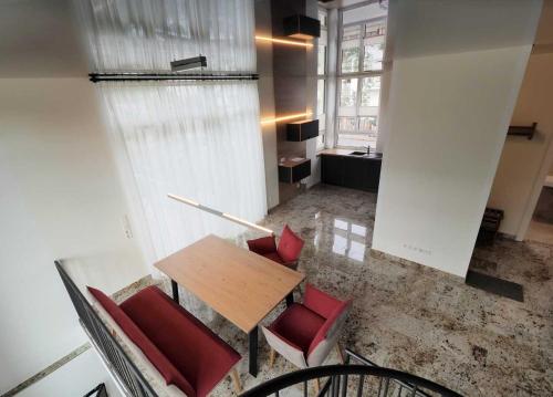 a room with a table and red chairs in a room at Ferienhaus Alte Glaserei in Neustadt an der Weinstraße