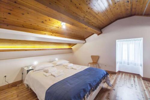 a bedroom with a large bed with a wooden ceiling at Casa Azul: A magic place in an authentic space in Mosteiros