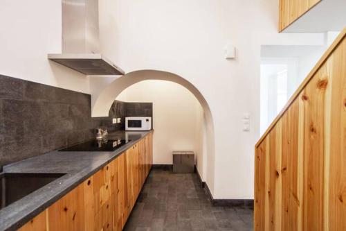 a kitchen with wooden cabinets and an archway at Casa Azul: A magic place in an authentic space in Mosteiros