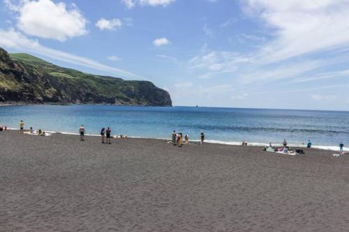 a group of people on a beach near the water at Casa Azul: A magic place in an authentic space in Mosteiros