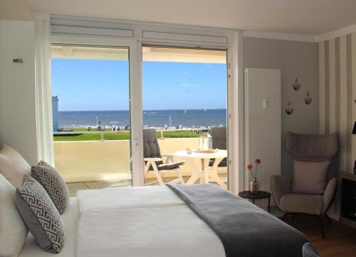 a bedroom with a bed and a view of the ocean at Meerblick SL 75 in Norderney
