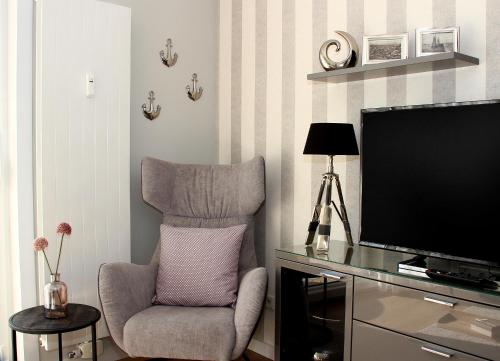 a living room with a chair and a flat screen tv at Meerblick SL 75 in Norderney