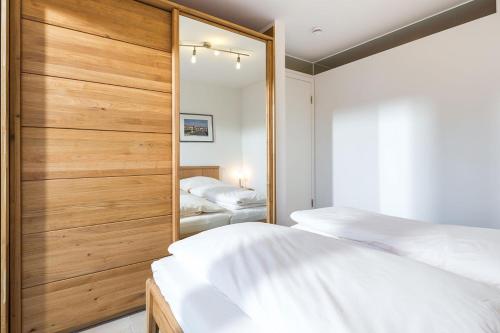 1 dormitorio con 2 camas y un espejo grande en Schippershuus 10, en Norderney