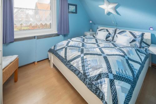 a bedroom with a bed with a blue wall at Rubintje Nord in Norderney