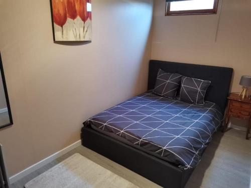 a bed in a room with a blue comforter at Marielu in Pouilly-sur-Loire