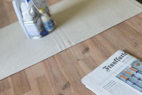 a newspaper on a bathroom floor with a remote control at Unser Haus in Norderney