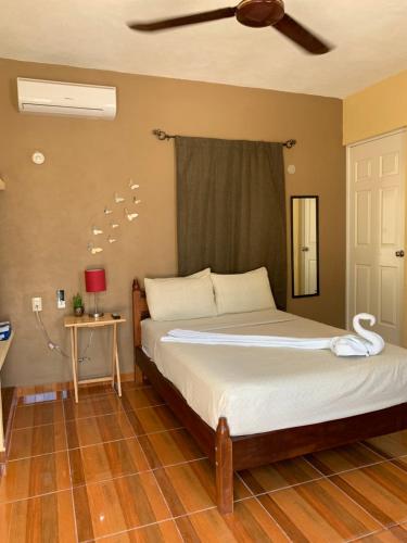 a bedroom with a bed and a ceiling fan at Estudios Rehilete in Holbox Island