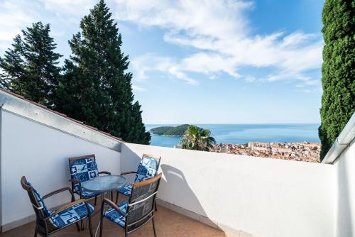 a balcony with a table and chairs overlooking the ocean at Apartment Srđ in Dubrovnik