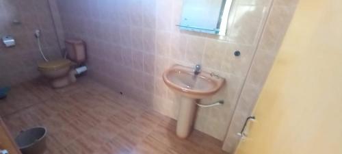 a bathroom with a sink and a toilet at Malika Homestay in Midigama