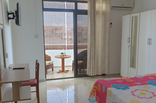 a bedroom with a bed and a table and a window at johnny's studio in Grand-Baie