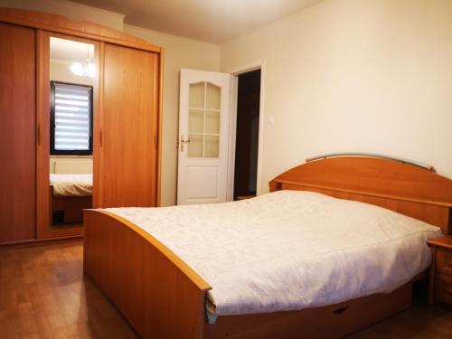 1 dormitorio con 1 cama grande y cabecero de madera en Irysek, en Lądek-Zdrój