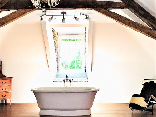 a white bath tub in a room with a window at Manoir du Bois Mignon in Le Fleix