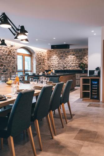 a dining room with a table and chairs and a kitchen at La ferme d'Edouard - Les Fermes Ardéchoises in Labatie-dʼAndaure