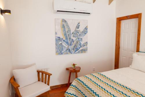 a bedroom with a bed and a chair at Angeli Gardens Boutique Hotel in San Pedro Sula