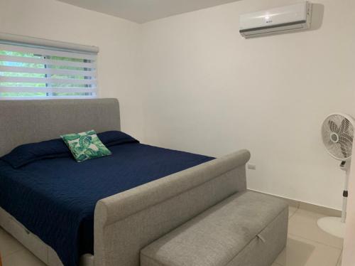 a bedroom with a bed and a chair and a fan at Furnished Apartment - Residencial Olas - Gated Community - 24 hr Security in San Felipe de Puerto Plata