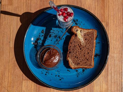un piatto blu con un pezzo di pane e un bicchiere di salsa di Malacuna Peniche a Peniche