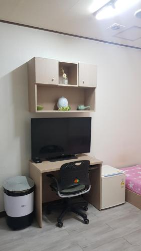 a desk with a monitor and a chair in a room at 아이원리빙텔 in Yongin