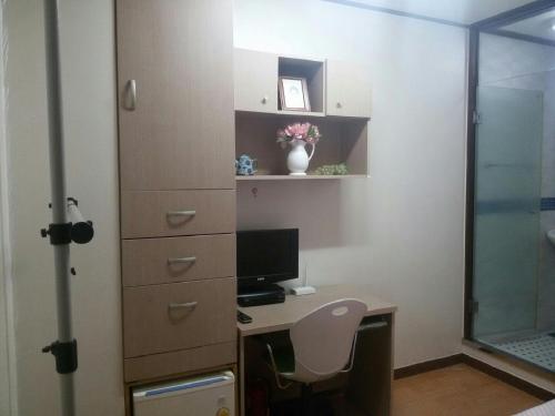 a room with a desk with a computer and a window at 아이원리빙텔 in Yongin