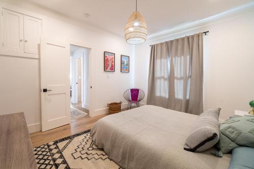 a white bedroom with a bed and a window at Plush 2-bed apt in Riverside Heights! in Reno