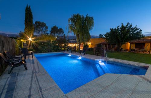 a swimming pool in a backyard at night at Los Sauces Posada in Nono