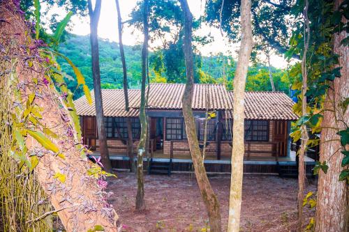a building in the middle of a forest of trees at Chalé 03 Itaipu Vale da Colina Niterói in Niterói